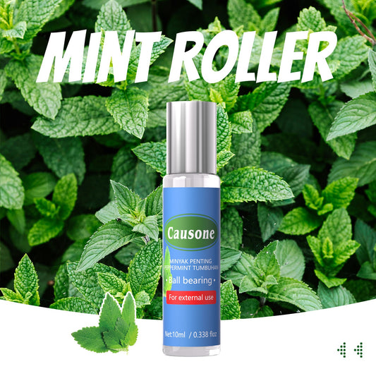 Portable peppermint roller essential oil displayed against fresh mint leaves